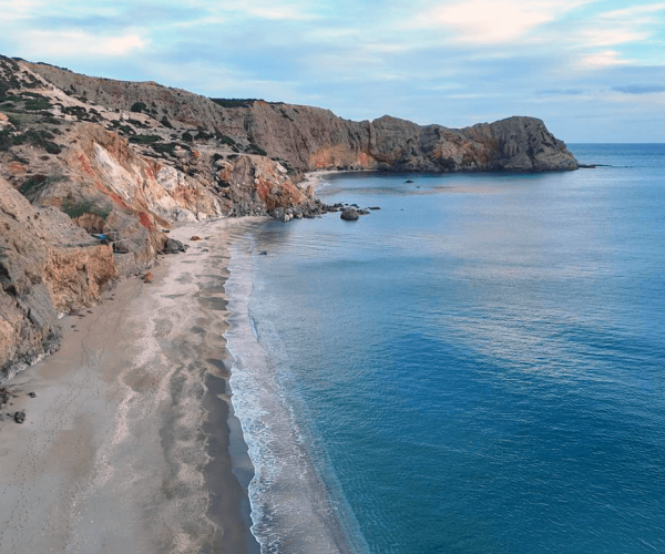 Beach framed by cliffs on the south coast of Milos
