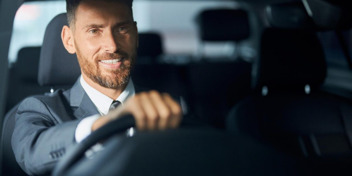 Elysium Transfer Milos chauffeur in a suit driving a client